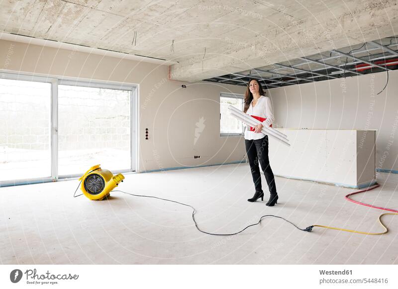 Woman in empty apartment looking around flat flats apartments female real estate agent standing woman females women architect female architect architects