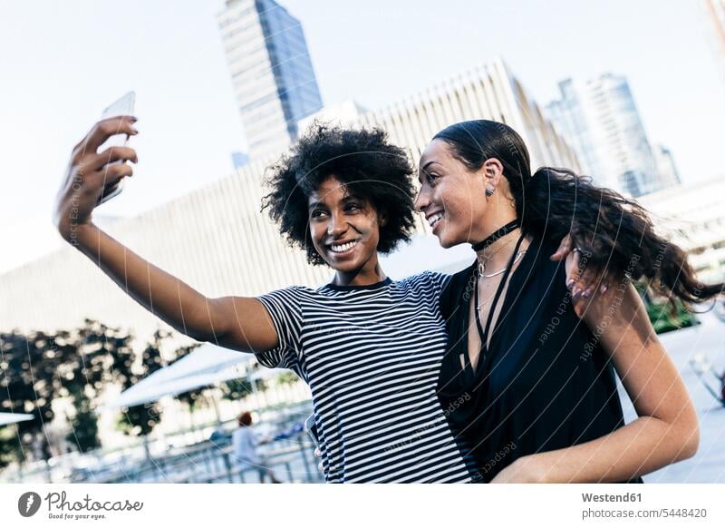 USA, New York City, two happy young women taking selfie with smartphone Selfie Selfies Smartphone iPhone Smartphones female friends mobile phone mobiles