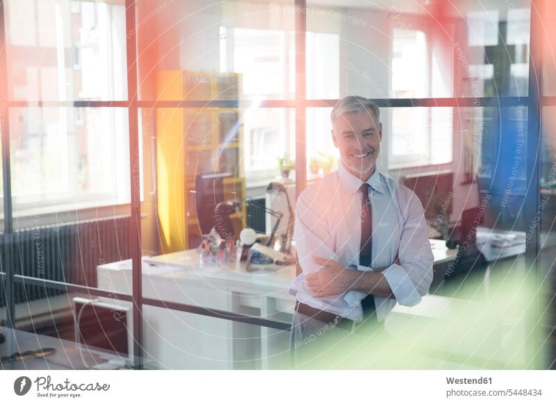 Mature businessman standing in office with arms crossed planning office working At Work expertise competence competent Planning planned Concentration