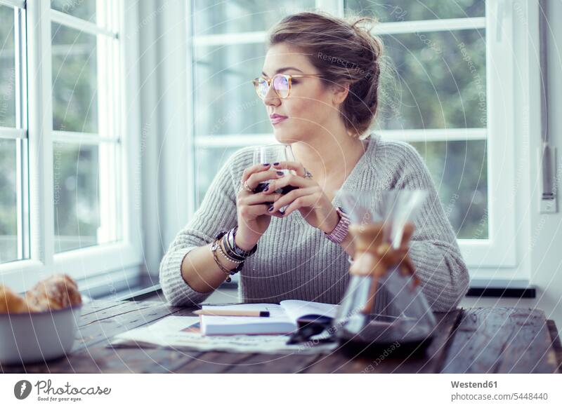 Young woman drinking coffee at table looking through window females women Adults grown-ups grownups adult people persons human being humans human beings Coffee