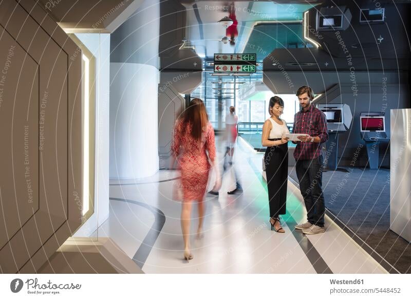 Business people discussing on a busy office corridor futuristic the future visionary Office Offices sharing share hallway corridors hallways business people