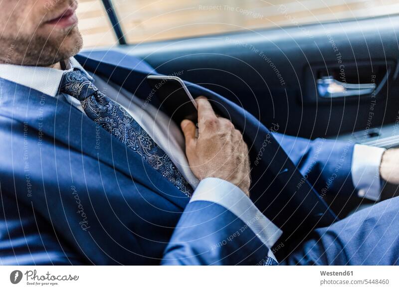 Businessman sitting in taxi, using smart phone attractive beautiful pretty good-looking Attractiveness Handsome commuter commuters Seated Taxies riding
