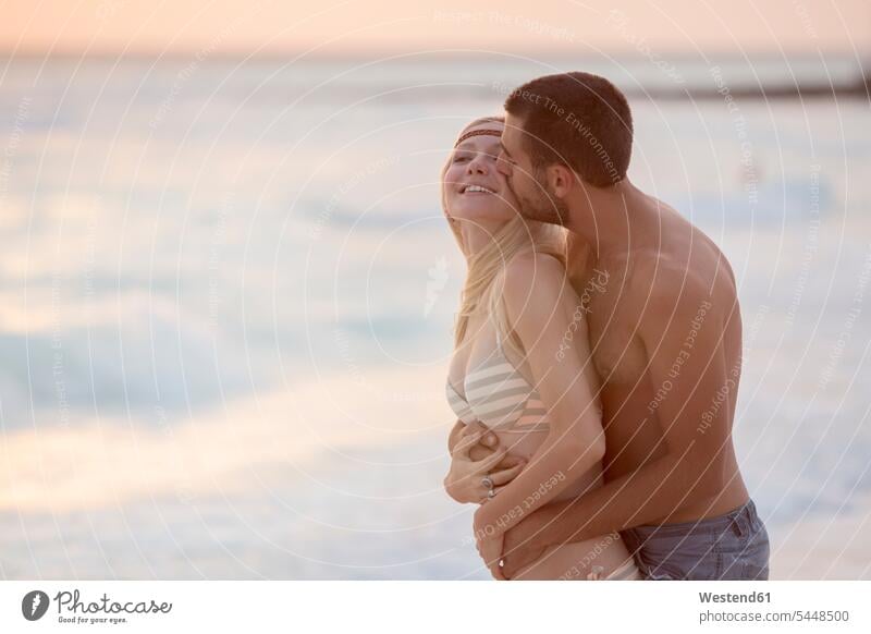 Romantic couple kissing on the beach vacation Holidays kisses eroticism sexuality happiness happy romantic lyrical Romance in love beaches Sea ocean embracing