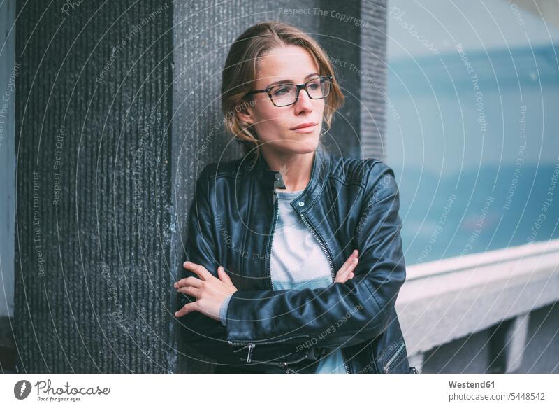 Young woman with glasses and leather jacket looking sideways females women Adults grown-ups grownups adult people persons human being humans human beings specs