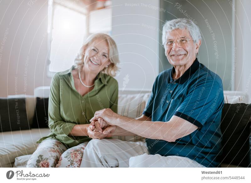 Portrait of smiling senior couple at home twosomes partnership couples couch settee sofa sofas couches settees senior men senior man elder man elder men