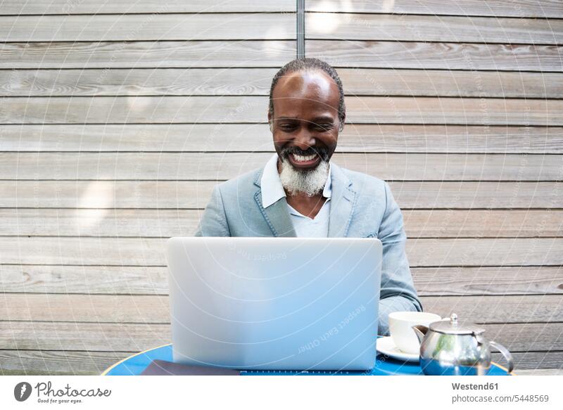 Portrait of laughing bearded man using laptop Businessman Business man Businessmen Business men Laptop Computers laptops notebook business people businesspeople