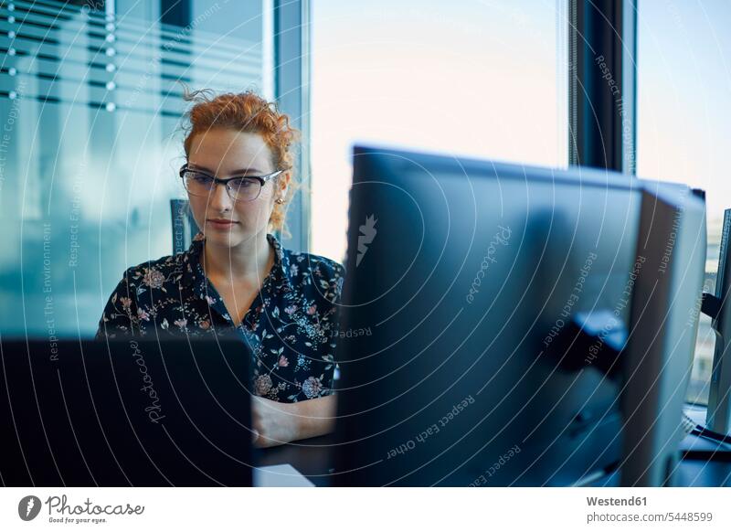 Businesswoman working at desk in office businesswoman businesswomen business woman business women At Work offices office room office rooms business people