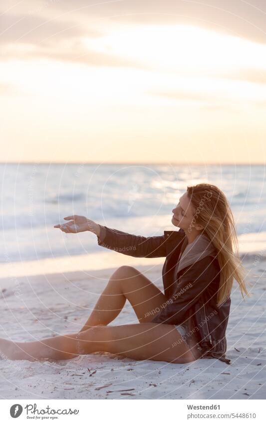 Young woman enjoying the beach at sunset beaches getting away from it all Getting Away From All unwinding relaxing Sea ocean vacation Holidays sitting Seated