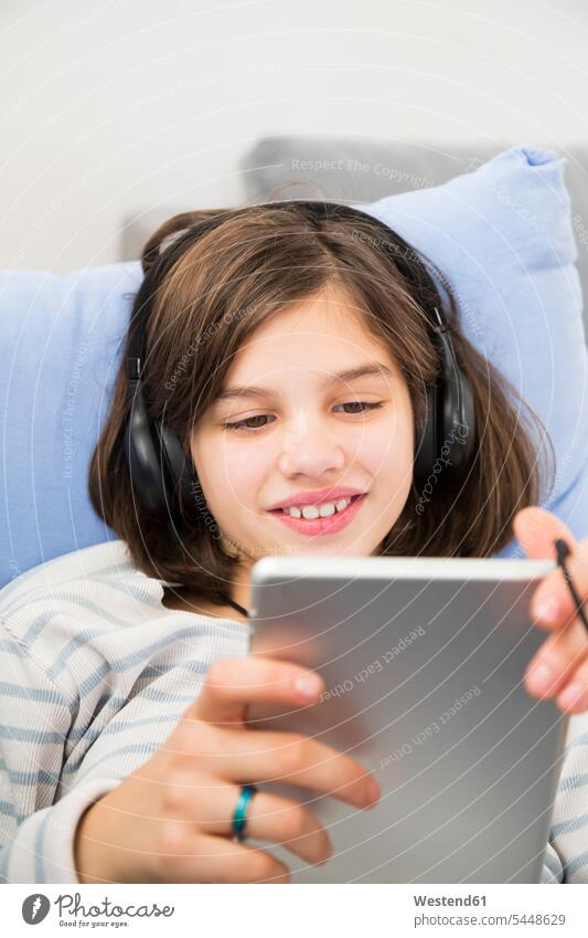Portrait of smiling girl using tablet and headphones at home headset females girls use digitizer Tablet Computer Tablet PC Tablet Computers iPad Digital Tablet
