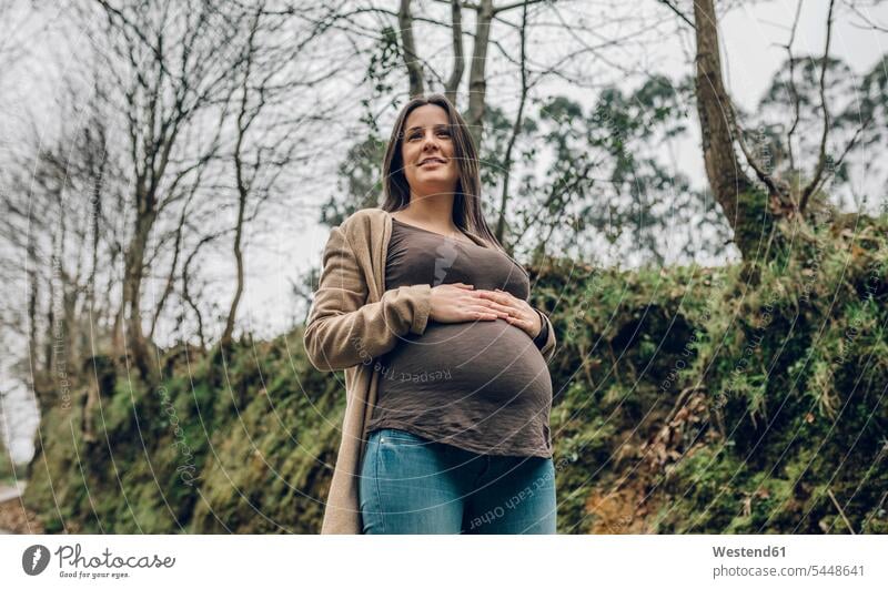 Smiling pregnant woman in forest in autumn smiling smile females women Pregnant Woman Adults grown-ups grownups adult people persons human being humans