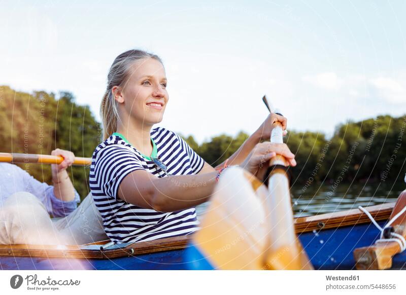 Young couple enjoying a trip in a canoe with sail on a lake excursion Getaway Trip Tours Trips indulgence enjoyment savoring indulging lakes twosomes