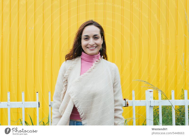 Portrait of smiling woman in front of yellow background portrait portraits females women Adults grown-ups grownups adult people persons human being humans