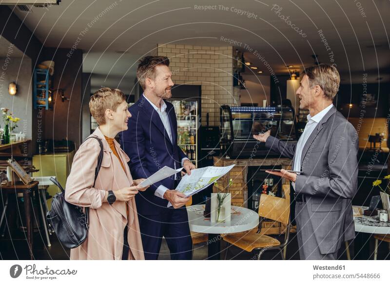 Woman and two businessmen discussing plans in a cafe smiling smile Planning planning planned talking speaking business partner associates business associates