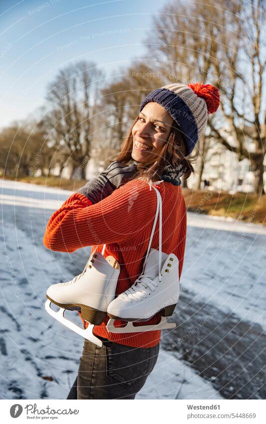 Happy woman on canal carrying ice skates laughing Laughter females women ice skating positive Emotion Feeling Feelings Sentiments Emotions emotional Ice-Skating