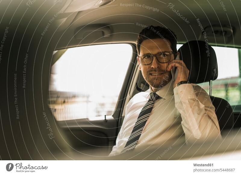 Successful businessman sitting in car talking on the phone successful glasses specs Eye Glasses spectacles Eyeglasses Shirt and Tie occupation profession