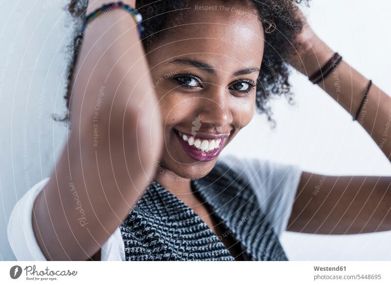 Portrait of smiling young woman with hands in her hair portrait portraits smile females women Adults grown-ups grownups adult people persons human being humans