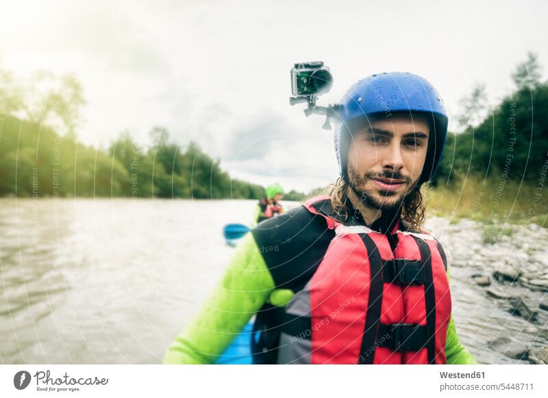 Germany, Bavaria, Allgaeu, portait of confident young man with action cam kayaking on river Iller River Rivers canoe portrait portraits men males water waters