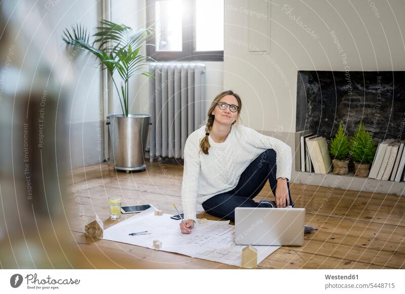 Woman sitting on the floor with blueprint and laptop Blueprint Blueprints Building Plan architectural drawing Construction Plan Laptop Computers laptops