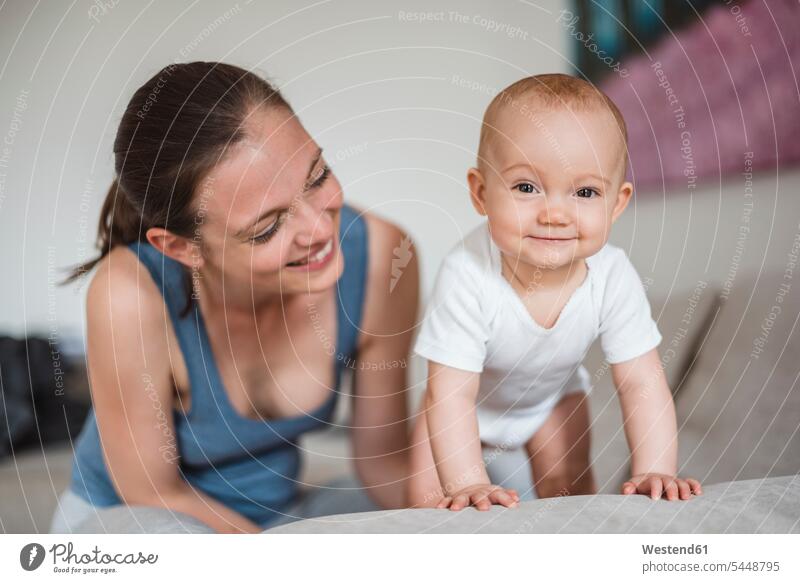 Portrait of baby girl with mother on couch portrait portraits infants nurselings babies smiling smile mommy mothers ma mummy mama people persons human being