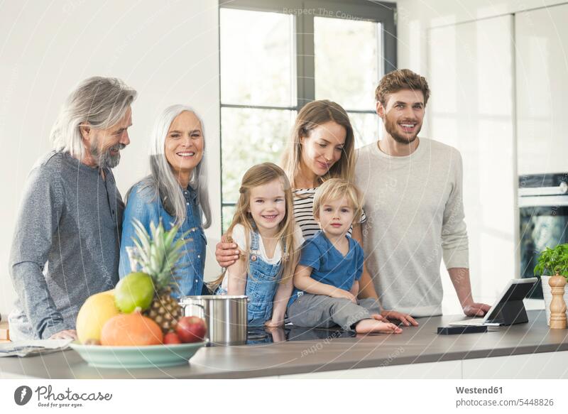 Happy family with grandparents and children standing in the kitchen together Family reunion domestic kitchen kitchens happiness happy cooking families recipe