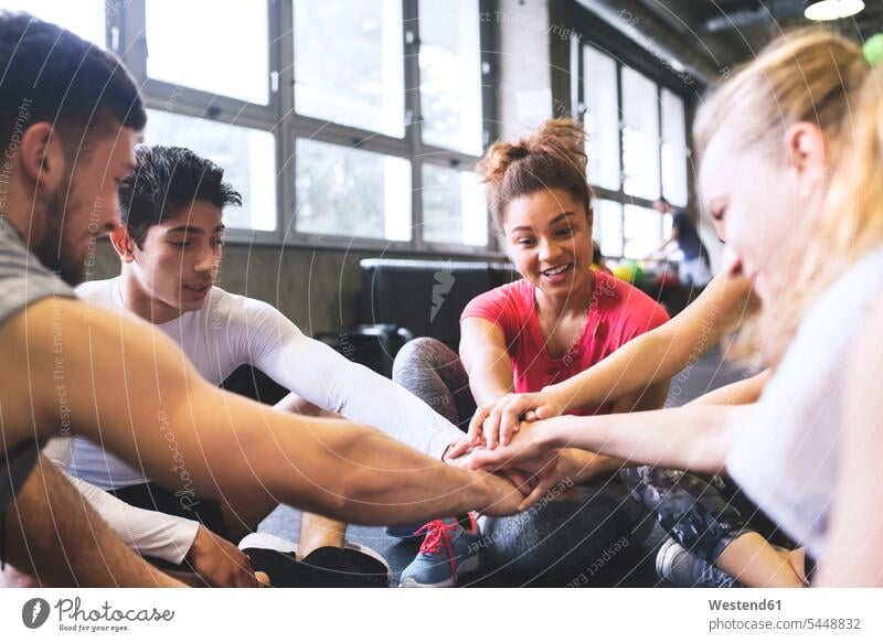 Group of young people having a break and huddling in gym team exercising exercise training practising smiling smile gyms Health Club Fitness training sport