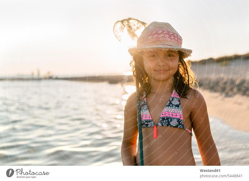 Spain, Menorca, portrait of a girl with a dip net on the beach dip nets scoop nets landing net females girls playing smiling smile beaches child children kid