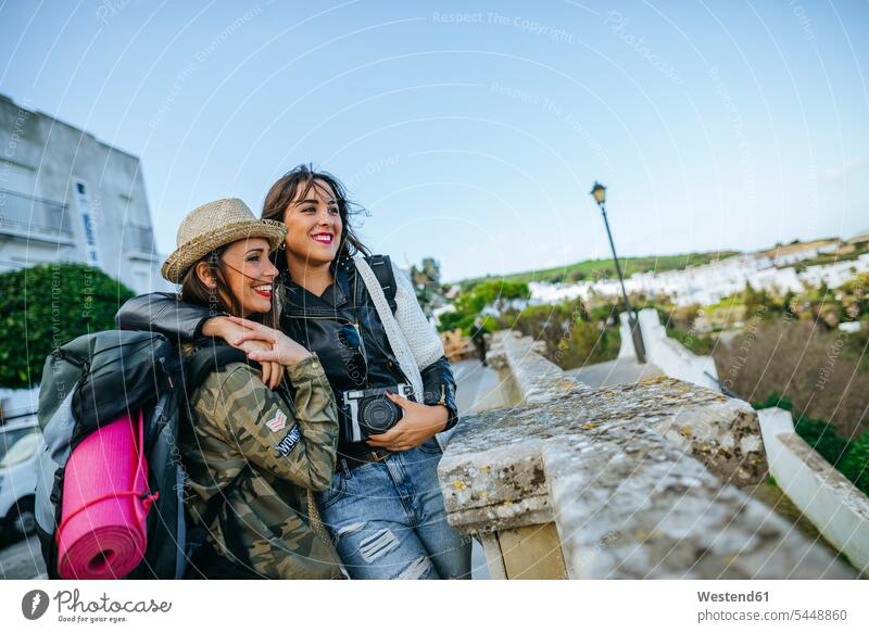 Two happy young women on a trip female friends camera cameras mate friendship female tourist woman females tourists tourism touristic Adults grown-ups grownups