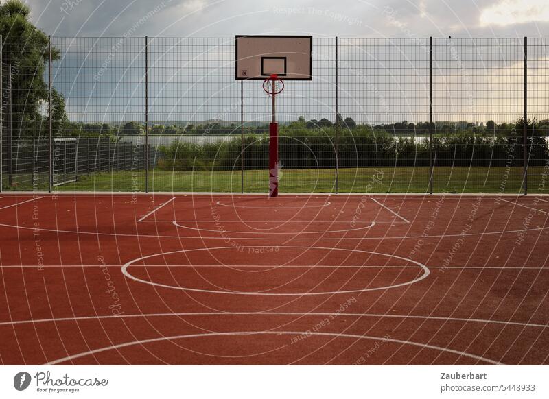 Sports field, basketball court with basketball hoop and fence, white lines on red background Sporting grounds Basketball Red Fence Playing fun Ball game