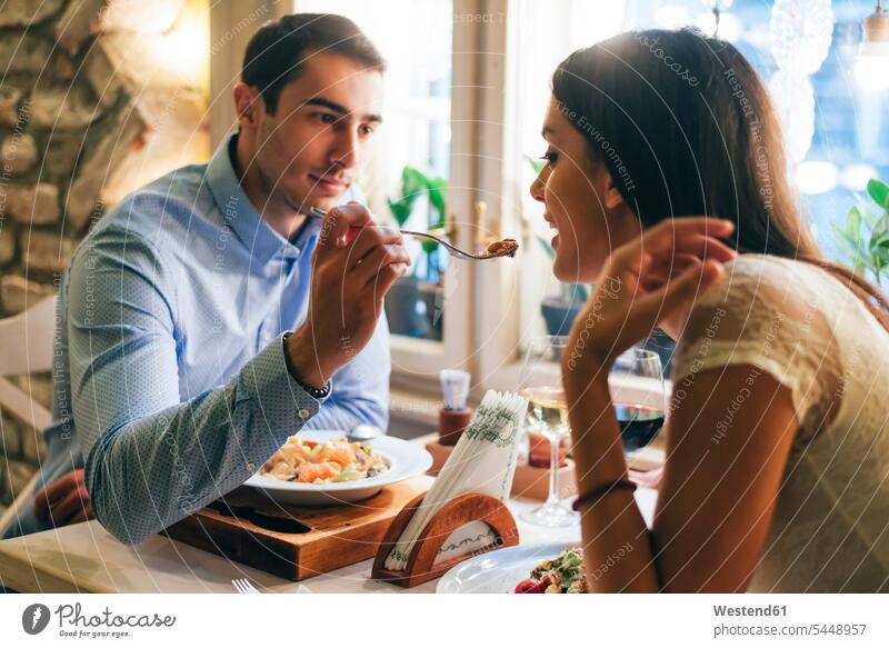 Couple having dinner in a restaurant restaurants couple twosomes partnership couples eating people persons human being humans human beings feeding sitting