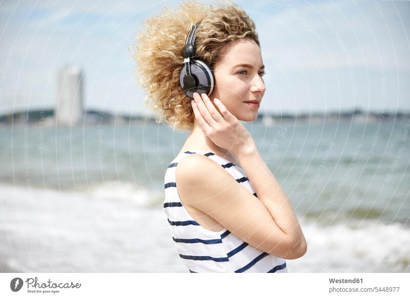 Portrait of young blond woman with headphones on the beach headset portrait portraits females women Adults grown-ups grownups adult people persons human being