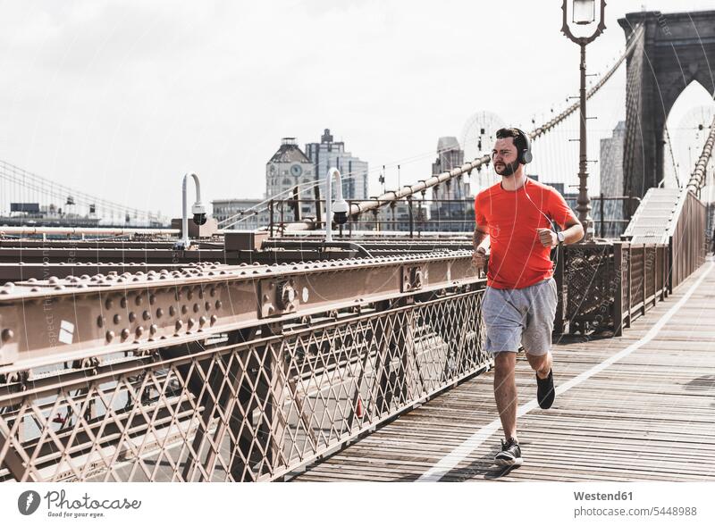 USA, New York City, man running on Brooklyn Brige bridge bridges men males Jogging headphones headset Adults grown-ups grownups adult people persons human being