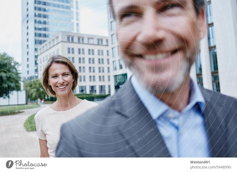 Happy businesswoman and businessman outdoors businesswomen business woman business women portrait portraits smiling smile Businessman Business man Businessmen