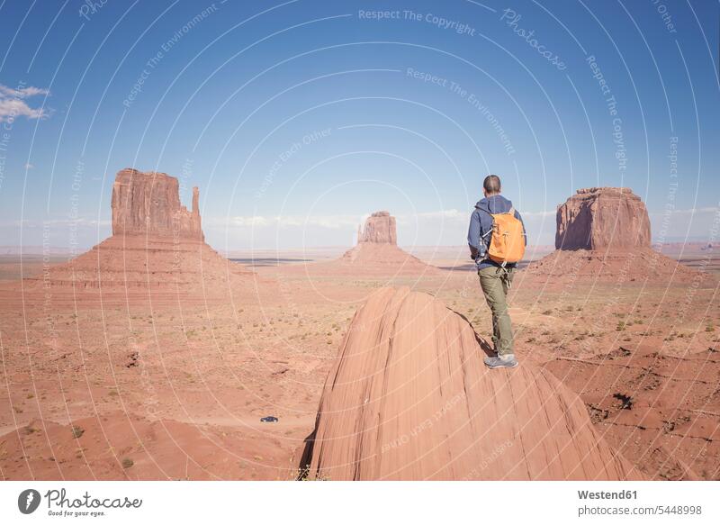 USA, Utah, back view of man with backpack looking at Monument Valley tourist tourists males tourism touristic Adults grown-ups grownups adult people persons