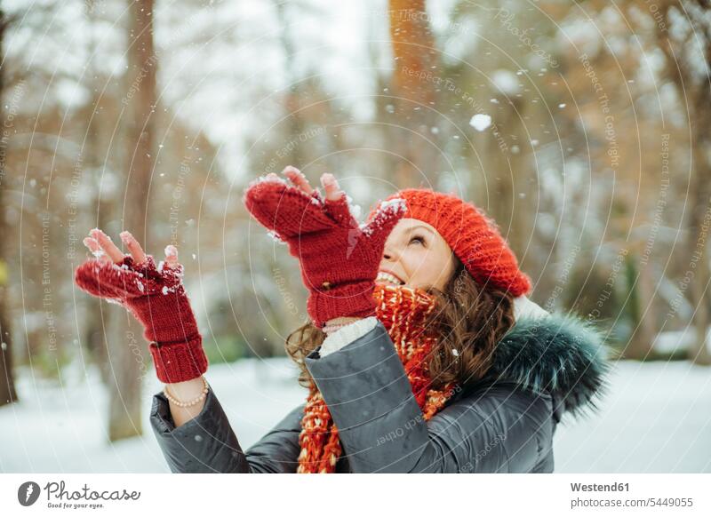 Happy woman catching snowflakes females women weather Adults grown-ups grownups adult people persons human being humans human beings winter hibernal happiness
