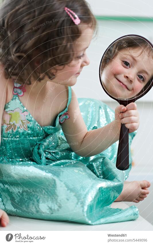 Mirror image of smiling little girl looking at hand mirror mirrors females girls portrait portraits child children kid kids people persons human being humans