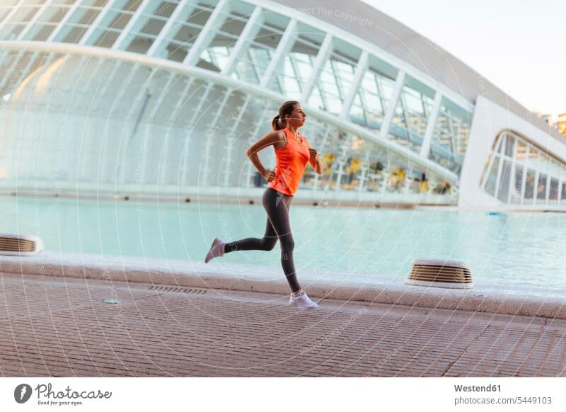 Spain, Valencia, woman running at Ciudad de las Artes y de Las Ciencias females women Jogging athlete sportswoman athletes female athlete sportswomen