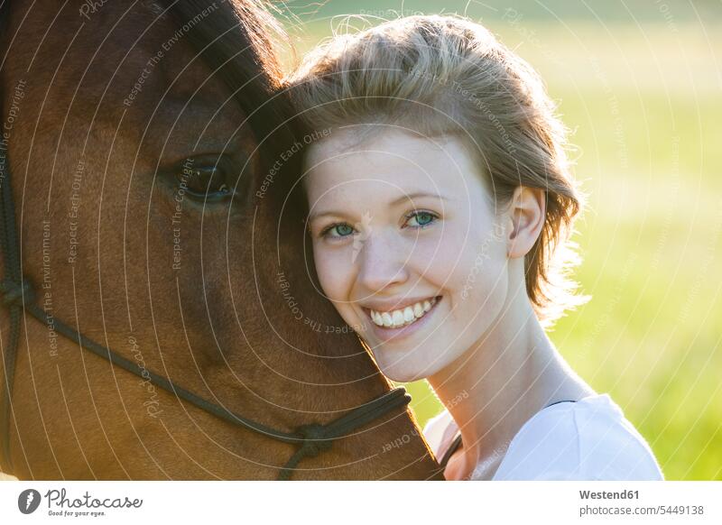 Portrait of happy of young woman with horse portrait portraits head to head natural naturally smiling smile looking at camera looking to camera