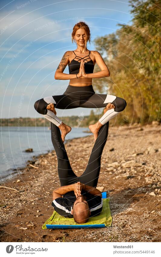 Young man and woman practicing Acro Yoga acrobatics Acrobatic Activity balancing balance exercise exercises practising exercising foot human foot human feet