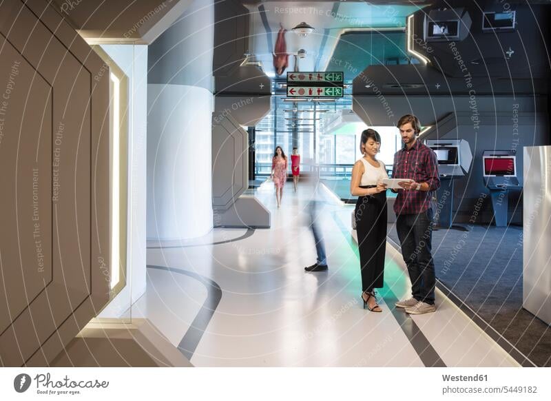 Business people discussing on a busy office corridor futuristic the future visionary Office Offices sharing share hallway corridors hallways business people