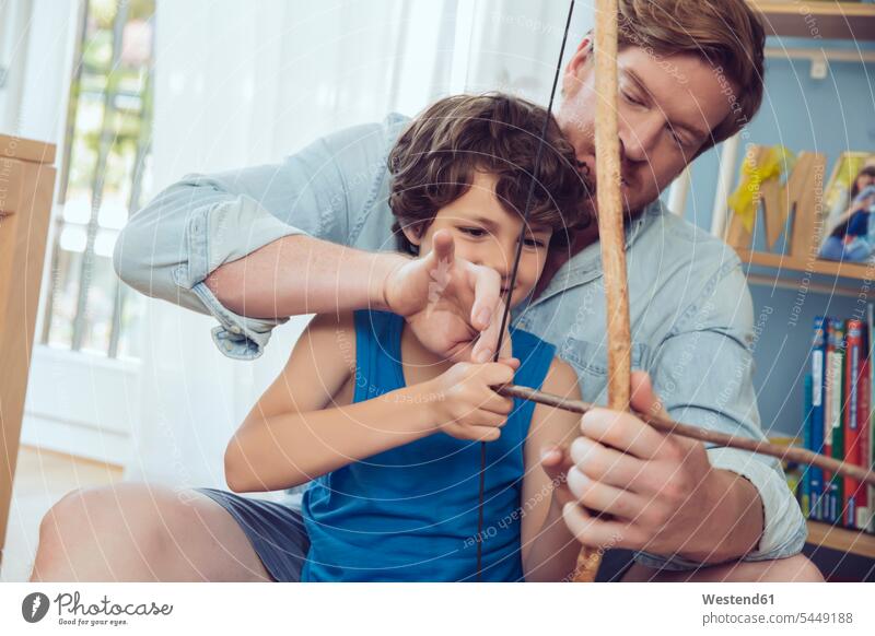 Father showing son how to use self-made bow and arrow father pa fathers daddy dads papa arrows sons manchild manchildren parents family families people persons