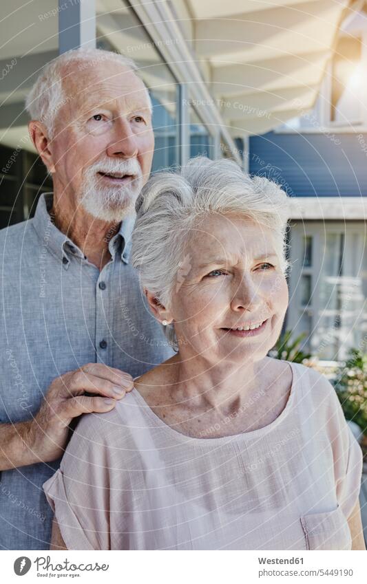 Senoir couple standing in their home, looking confident happiness happy twosomes partnership couples Aging Ageing senior adults seniors old terrace terraces