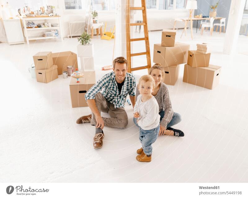 Portrait of smiling family moving into new home at home moving house move Moving Home smile families portrait portraits move in people persons human being