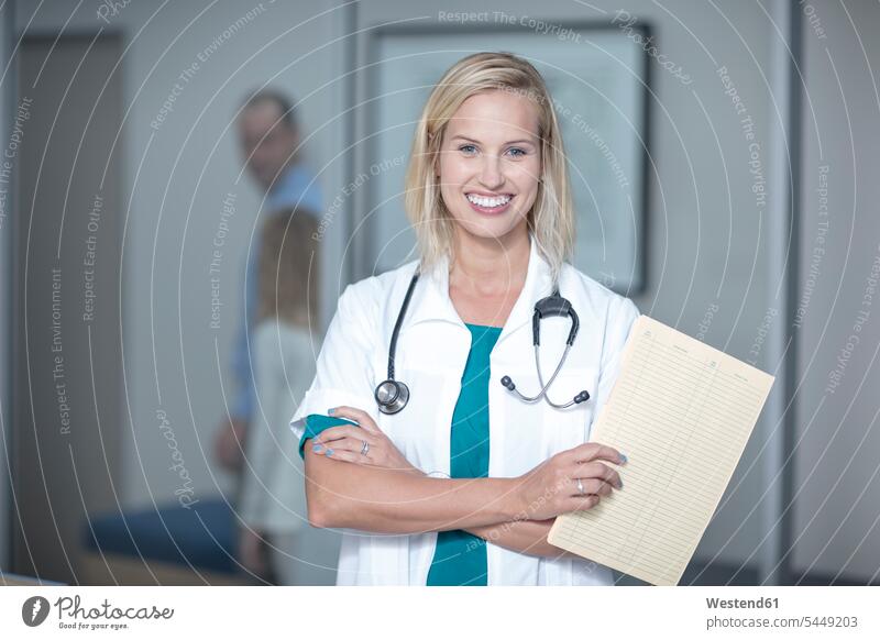 Young doctor holding patient's record physicians doctors Female Doctor Female Doctors clinic hospitals Medical Clinic medical chart medical file