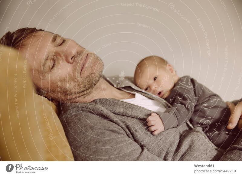 Father taking a nap with newborn awake on his chest sleeping asleep baby infants nurselings babies father pa fathers daddy dads papa people persons human being