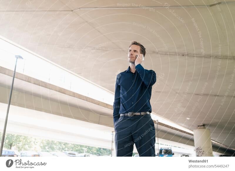 Businessman on cell phone at underpass Business man Businessmen Business men mobile phone mobiles mobile phones Cellphone cell phones on the phone call
