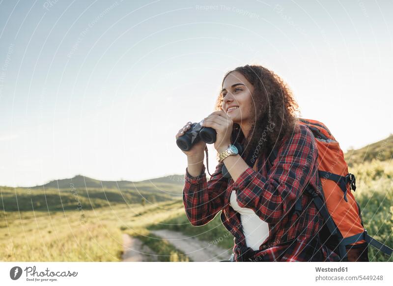 Teenage girl with backpack and binoculars in nature Teenage Girls female teenagers Teenager Teens people persons human being humans human beings Exploration