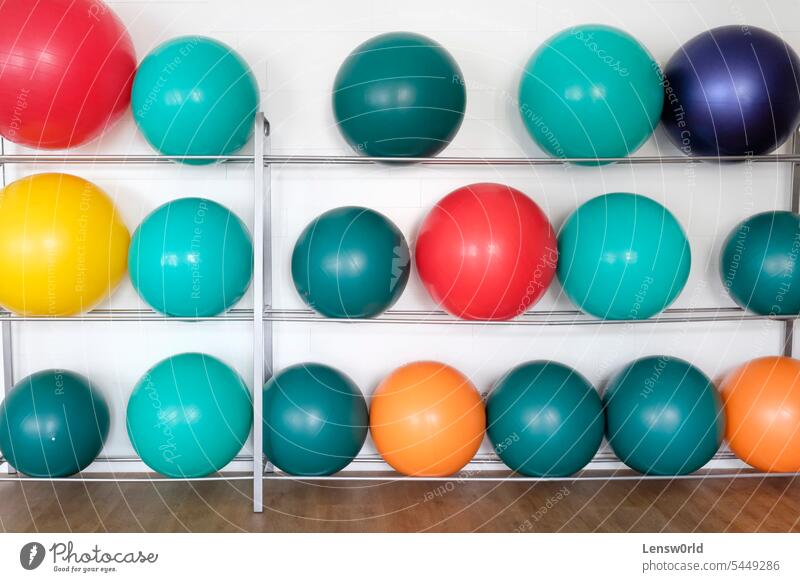 Colorful exercise balls in a shelf at a orthopedics center blue colorful convalescence doctors office equipment fit fitness gym healthy in a row lifestyle