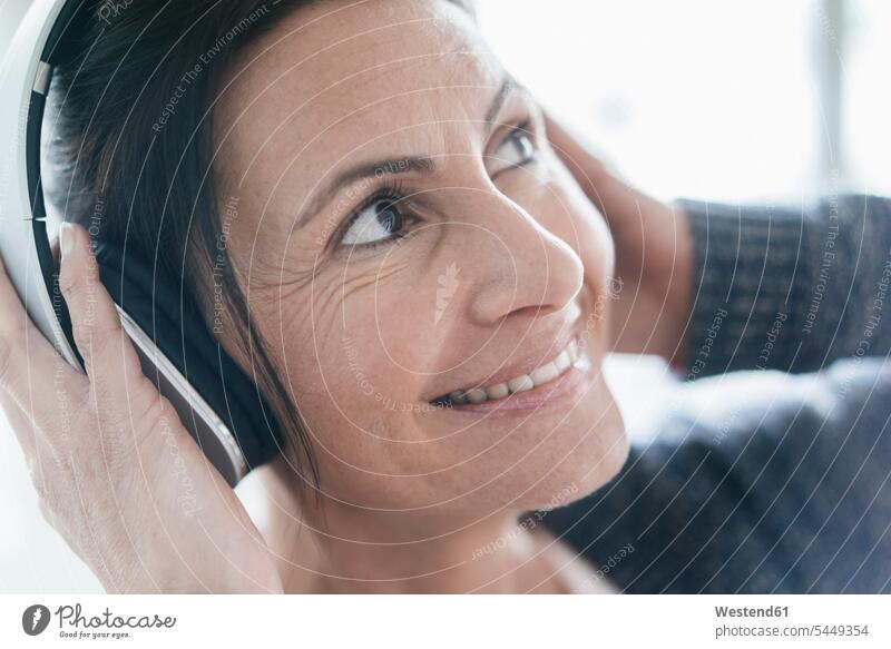 Portrait of smiling woman listening music with headphones females women portrait portraits headset Adults grown-ups grownups adult people persons human being