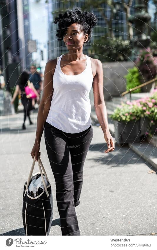 USA, New York City, Manhattan, smiling woman with shopping bag walking going females women bags Adults grown-ups grownups adult people persons human being
