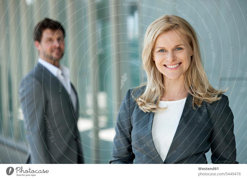 Portrait of smiling businesswoman with her partner watching in the background portrait portraits businesswomen business woman business women business people